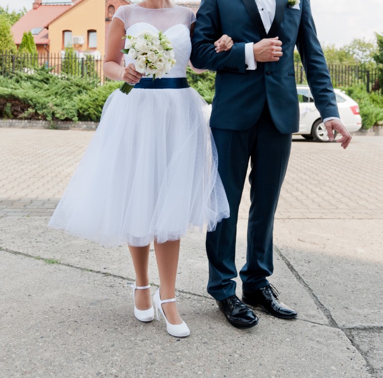 Krótka biała suknia ślubna z granatową kokardą