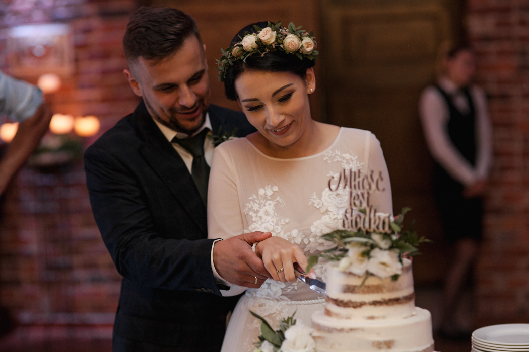 krojenie tortu ślubnego przez parę młodą 