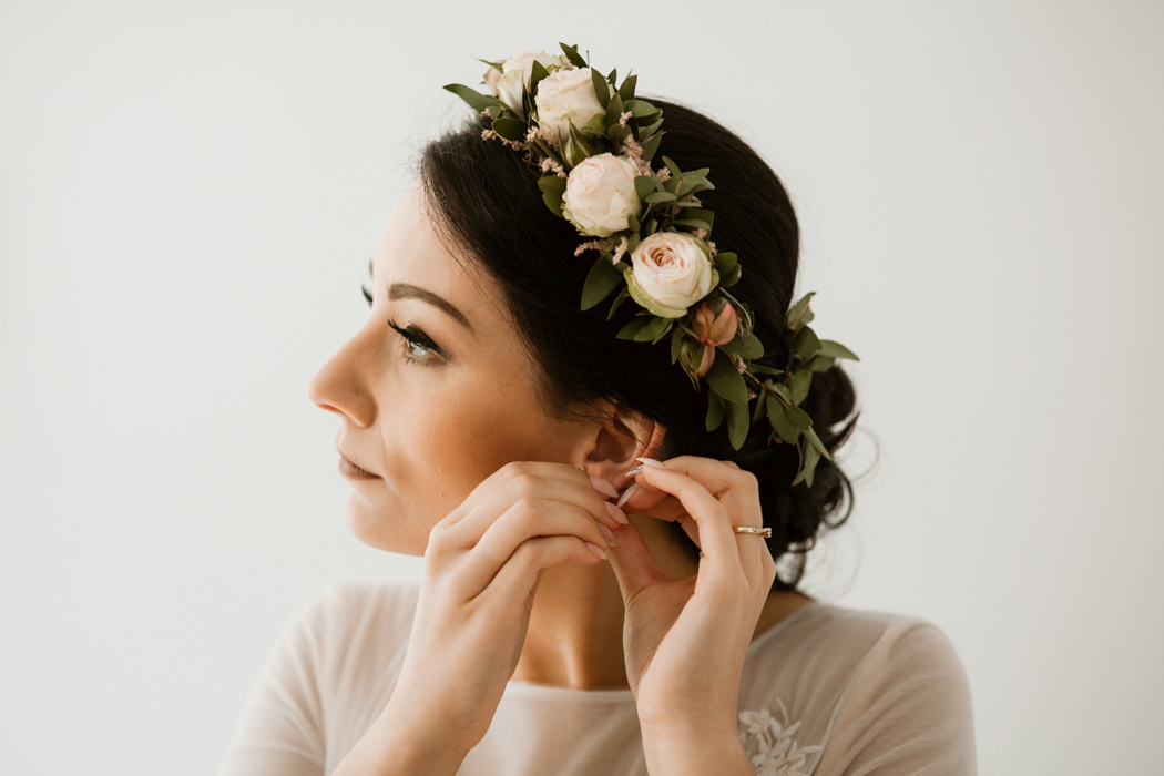 fryzura ślubna panny młodej z wiankiem z kwiatów
